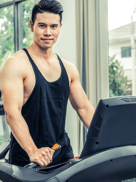 Sporty runner running on treadmill in fitness gym. Healthy lifestyle concept. - Valokuva, kuva