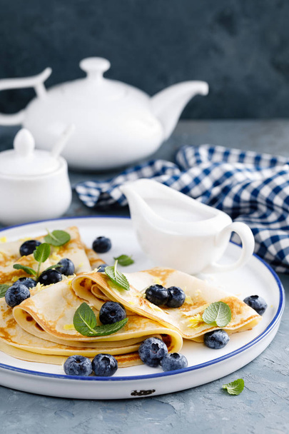 Sweet pancakes wrapped with fresh berries, crepes with blueberry - 写真・画像