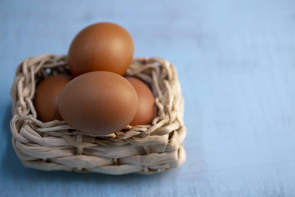 Paskalya yumurtaları sepet dekor ahşap arka plan üzerinde içinde - Fotoğraf, Görsel