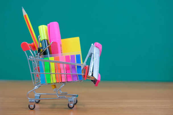 Back to school and Education concepts with shopping cart, pencil, staples, highlighter and notepad - Fotoğraf, Görsel