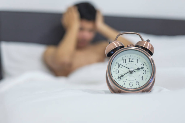 Aziatisch mens in bed laat in de nacht, jonge mannelijke slapen in slaapkamer thuis liggen. slapeloosheid slapen, bezorgd en benadrukt concepten - Foto, afbeelding