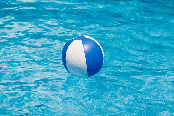 opblaasbare kleurrijke bal drijvend in een zwembad - Foto, afbeelding
