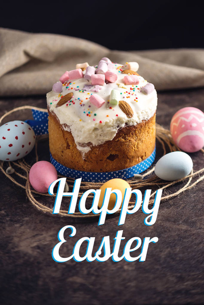 Traditional Easter cake and colorful eggs and text in rustic style on a dark background. Concept holiday card - Photo, Image