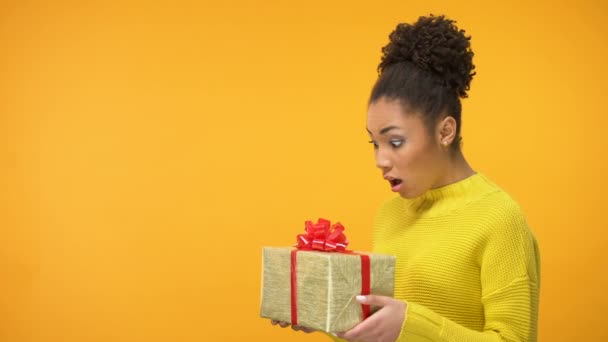 überraschte schwarze Frau mit Geburtstagsgeschenkschachtel, unerwartetes Geschenk, Hintergrund - Filmmaterial, Video