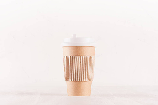 Coffee packing mockup -  craft brown paper cup with white cap and kraft cup holder on white wood board, coffee shop interior. Modern elegant concept for branding identity, advertising, design. - Photo, Image