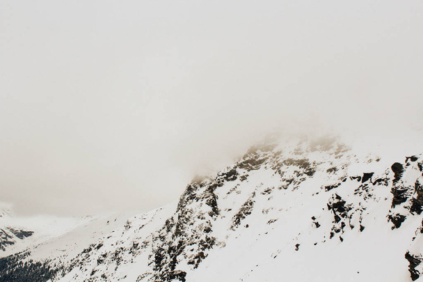 Beautiful cloudy view of alpeb mountains in winter fog - Fotó, kép
