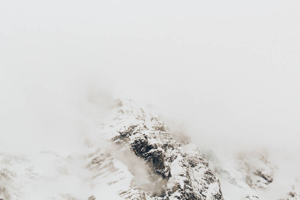 Beautiful cloudy view of alpeb mountains in winter fog - Foto, Imagen