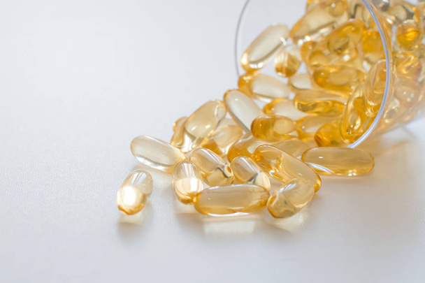 Supplementen. Transparante gele capsules op een witte achtergrond en plaats voor tekst. Vrije ruimte. Amega 3, visolie, vitamine. Biologisch actieve voedingssupplementen. platte lay - Foto, afbeelding