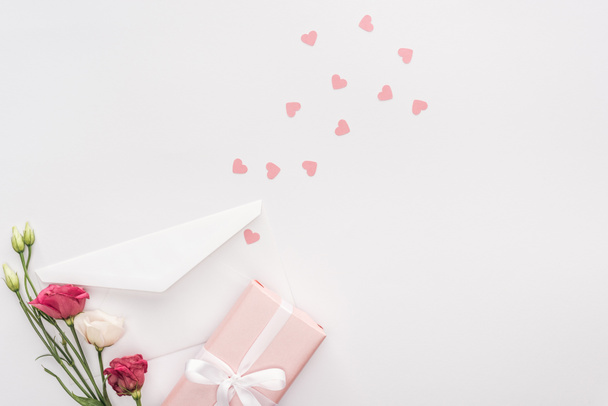 vista superior de la caja de regalo, flores, sobres y corazones de papel aislados en blanco
 - Foto, Imagen