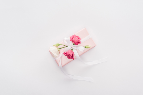 Şerit ve üzerinde beyaz izole çiçek hediye kutusu üstten görünüm - Fotoğraf, Görsel