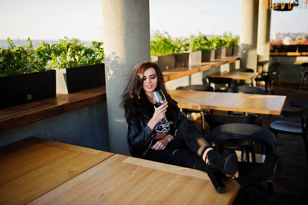 Young curly woman enjoying  her wine in a bar. - 写真・画像