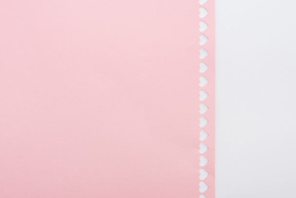 Hintergrund ausgeschnittene Herzen in Reihe auf rosa Papier isoliert auf weiß mit Kopierraum - Foto, Bild