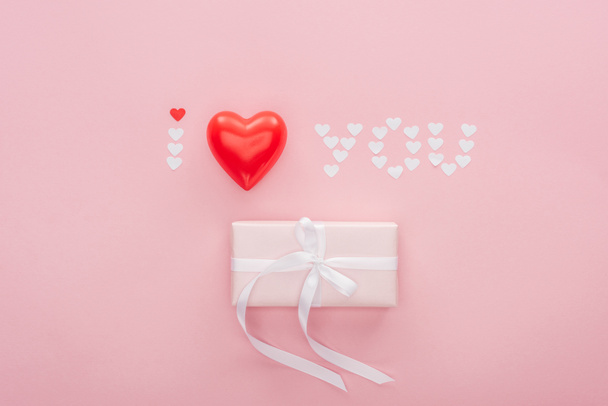 top view of gift box and 'i love you' lettering made of paper hearts isolated on pink, st valentines day concept - Фото, зображення