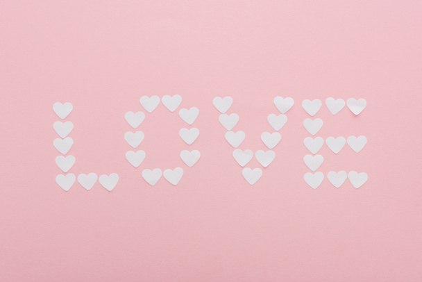 top view of 'love' word made of paper hearts isolated on pink, st valentines day concept - Foto, imagen