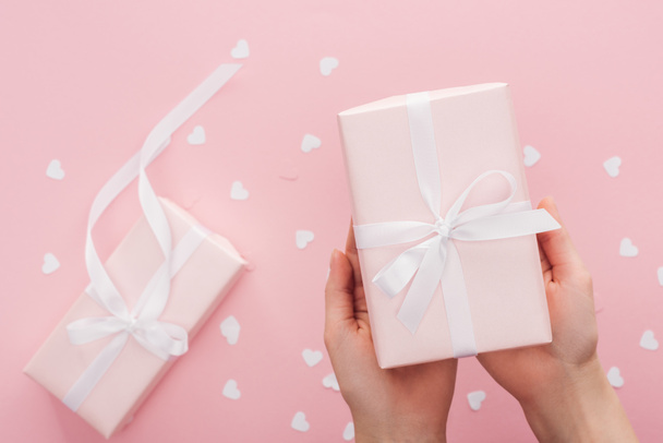 cropped view of woman holding gift box isolated on pink - Foto, imagen