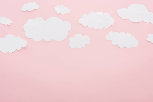 верхний вид белых бумажных облаков изолированы на розовый с копировальным пространством
 - Фото, изображение