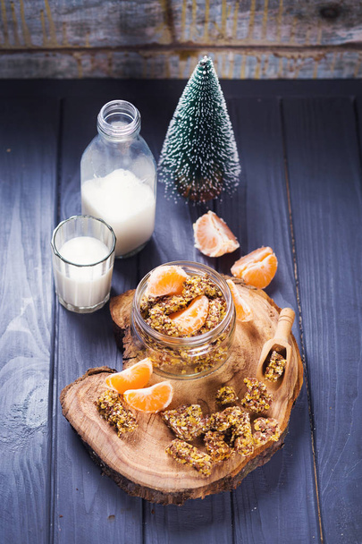 granola with mandarin and milk-healthy breakfast on wooden board - Photo, image