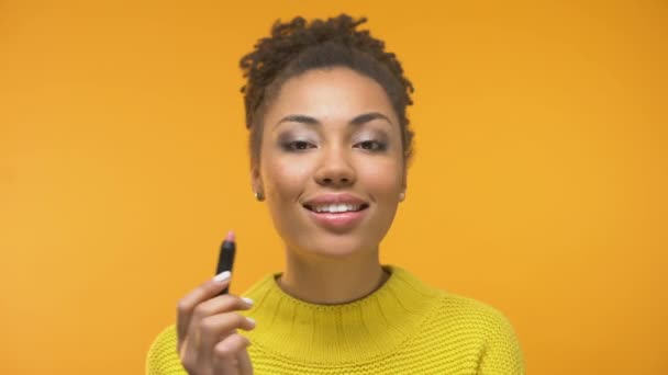 Pretty African-American girl applying lipstick and winking, ready for date - Imágenes, Vídeo
