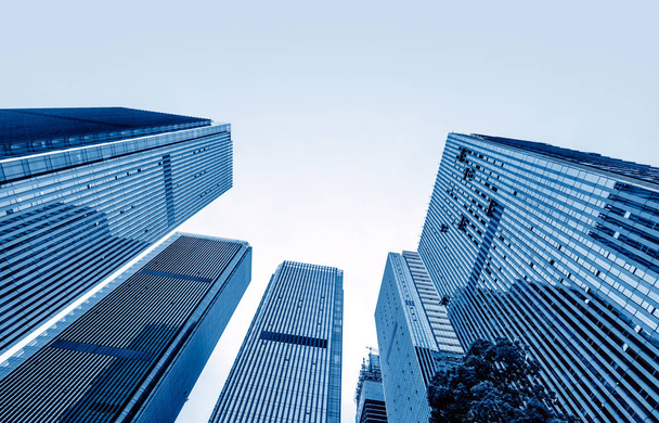 Dolní pohled na moderní mrakodrapy v obchodní čtvrti proti modré obloze - Fotografie, Obrázek