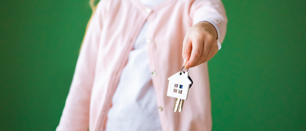 cropped view of kid holding house shaped key chain isolated on green - Photo, Image