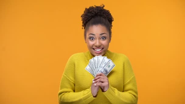 Excited African-American woman holding bunch of dollars, lottery winner, fortune - Кадри, відео