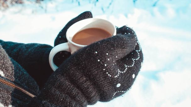 Warm cup of hot coffee warming in the hands of a girl - Fotoğraf, Görsel