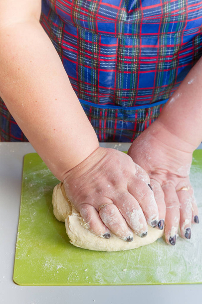 Knead the dough with your hands on the table - Zdjęcie, obraz