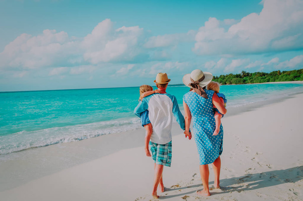 familia feliz con dos niños a pie en la playa tropical
 - Foto, Imagen