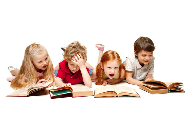 El niño y las niñas acostados con libros aislados en blanco
 - Foto, imagen