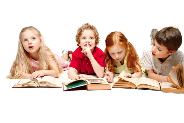 De kinderen jongen en meisjes leggen met boeken geïsoleerd op wit - Foto, afbeelding