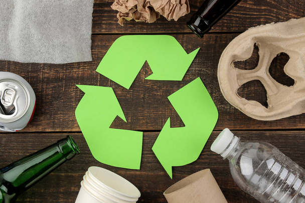Οικολογικό σύμβολο. ανακύκλωση. Οικολογική αντίληψη για καφετί ξύλινο τραπέζι. ανακύκλωση των αποβλήτων. το top view. - Φωτογραφία, εικόνα