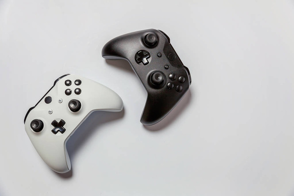 Белый и черный два джойстика, геймпады, игровые консоли изолированы друг от друга
  - Фото, изображение