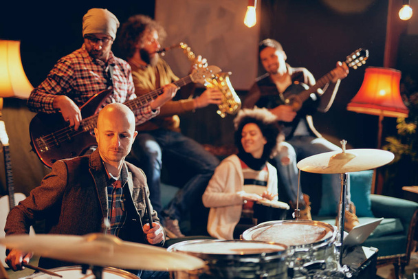 Zespół jazzowy, grający muzykę w domowym studio. Selektywny fokus na perkusista. - Zdjęcie, obraz