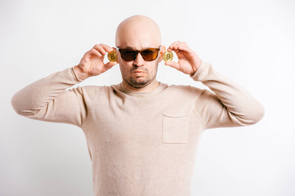 portrait of funny bald man showing bitcoins - 写真・画像