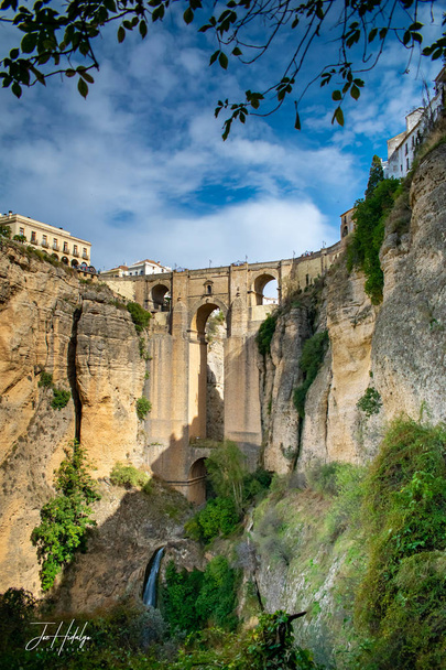 ten strzał jest głównym mostu, który znajduje się w mieście Ronda, Hiszpania. Most łączy obie strony miasta nad małą rzekę i wodospad pod  - Zdjęcie, obraz