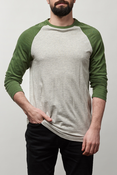 visão parcial do homem barbudo em camisa de beisebol raglan manga com espaço de cópia isolado em cinza
 - Foto, Imagem