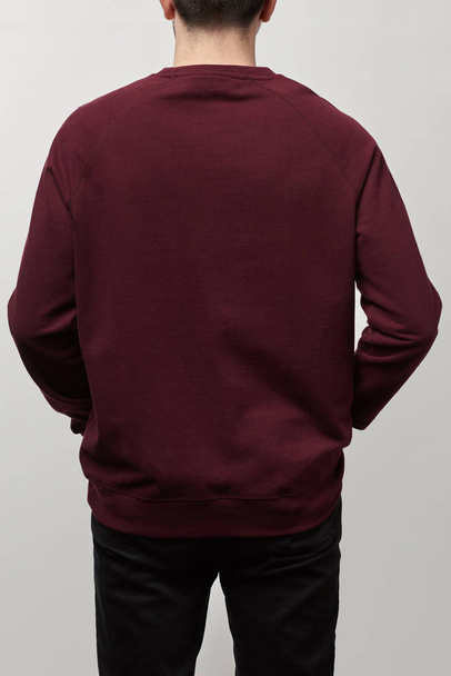vista trasera del hombre en sudadera casual de color burdeos con espacio de copia aislado en gris
 - Foto, imagen