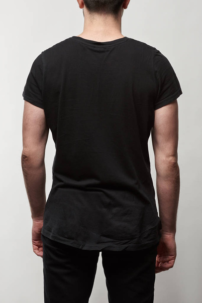 back view of man in black t-shirt with copy space isolated on grey - Фото, зображення