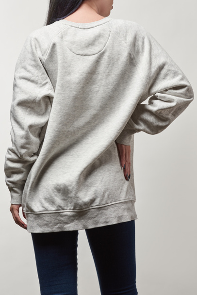 back view of young woman in grey hoodie with copy space isolated on white - Valokuva, kuva