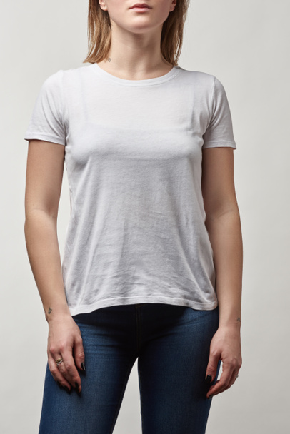 partial view of young woman in white t-shirt with copy space isolated on grey - Φωτογραφία, εικόνα