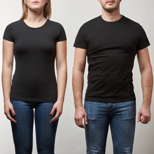 cropped view of young man and woman in black t-shirts with copy space isolated on grey - 写真・画像