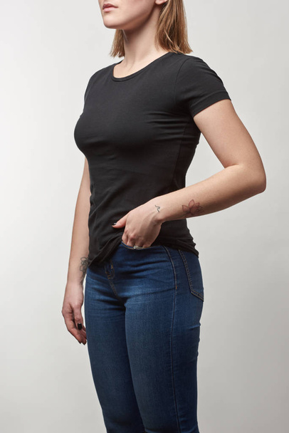 cropped view of young woman in black t-shirt with copy space isolated on white - Foto, Imagen