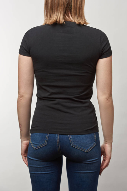 back view of young woman in black t-shirt with copy space isolated on white - Zdjęcie, obraz