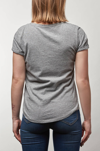 vista trasera de la joven en camiseta gris con espacio de copia aislado en blanco
 - Foto, Imagen