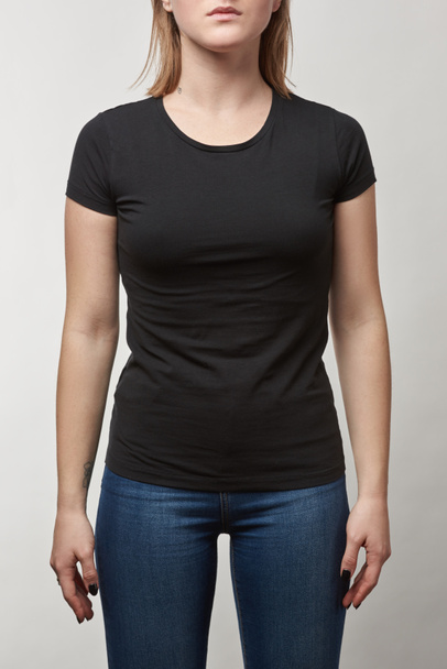 vista parcial de mujer joven en camiseta negra casual con espacio de copia aislado en blanco
 - Foto, Imagen