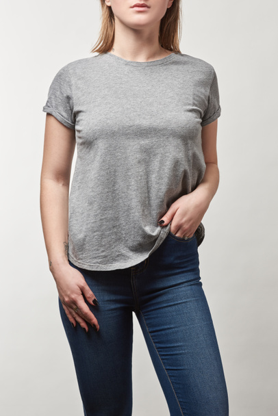 cropped view of young woman with hand in pocket in grey t-shirt with copy space isolated on white - Foto, Imagen