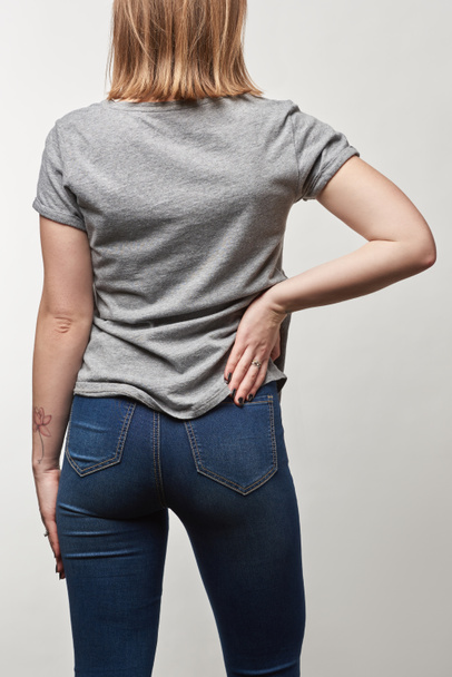 vista trasera de mujer joven en camiseta gris casual con espacio de copia aislado en blanco
 - Foto, Imagen