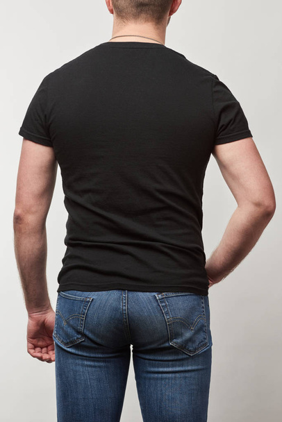 back view of man in black t-shirt with copy space isolated on grey - Foto, Bild