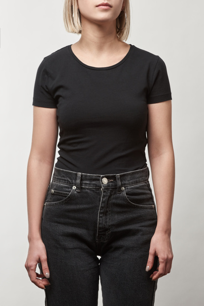 partial view of young woman in casual black t-shirt with copy space isolated on white - Valokuva, kuva
