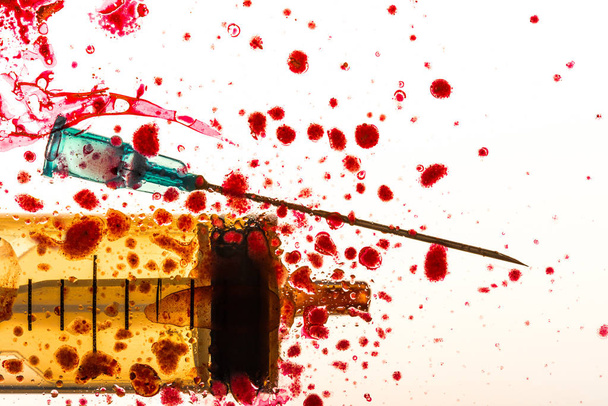Studio shot of syringe, needle and blood splashes - Photo, Image